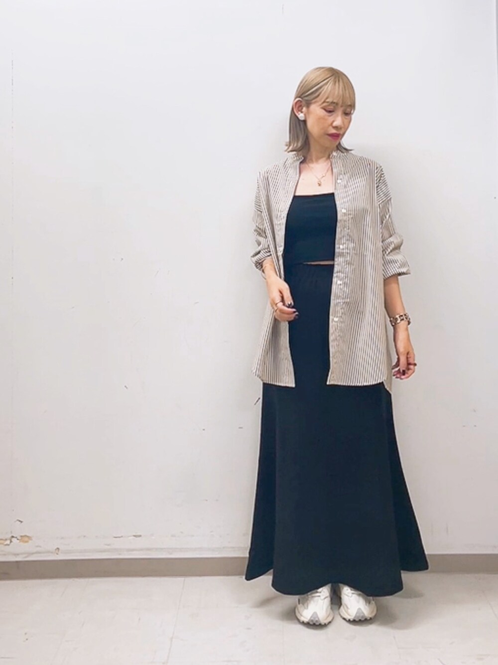ホワイト系のスニーカー、ブラック系のスカート、ブラウン系のシャツ/ブラウスを着用したレディースの夏コーディネートの1枚目の写真