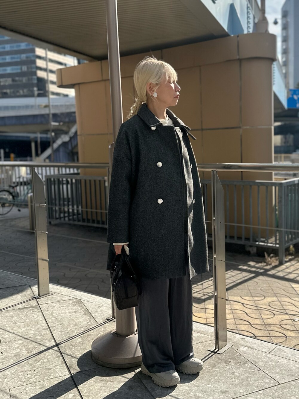 グレー系のその他アウター、グレー系のその他パンツ、ブラック系のハンドバッグを着用したレディースの冬コーディネートの1枚目の写真