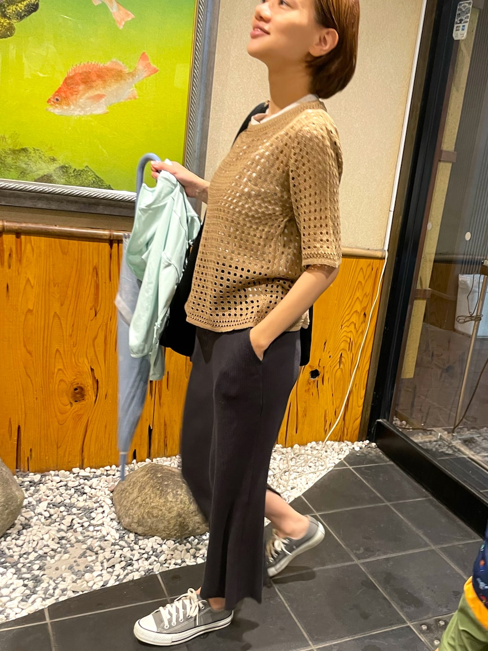 ブラウン系のTシャツ/カットソー、ブラック系のスカート、グレー系のスニーカーを着用したレディースの夏コーディネートの1枚目の写真