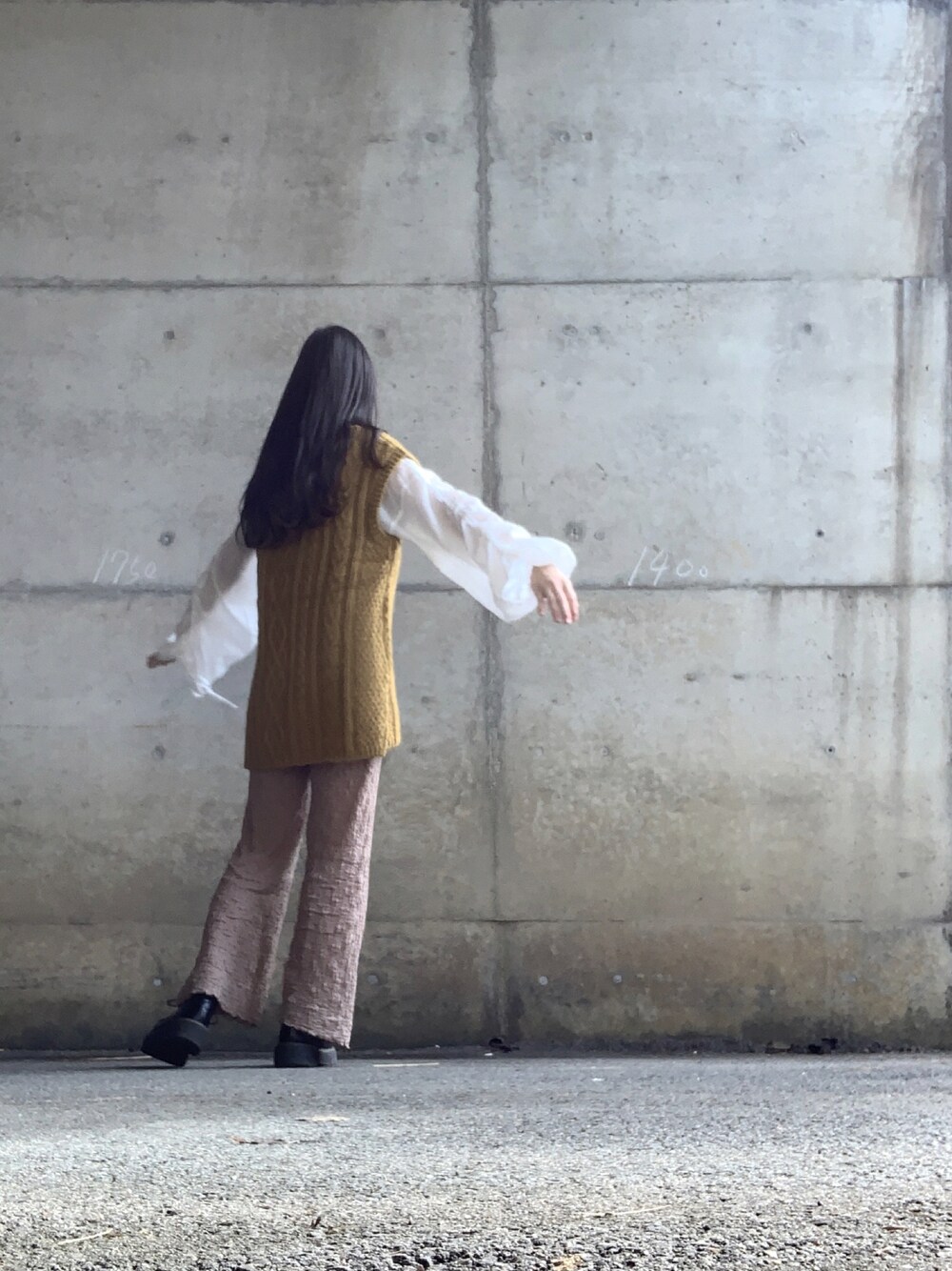 ブラウン系のパンツ、ホワイト系のシャツ/ブラウス、イエロー系のベストを着用したレディースの秋コーディネートの1枚目の写真