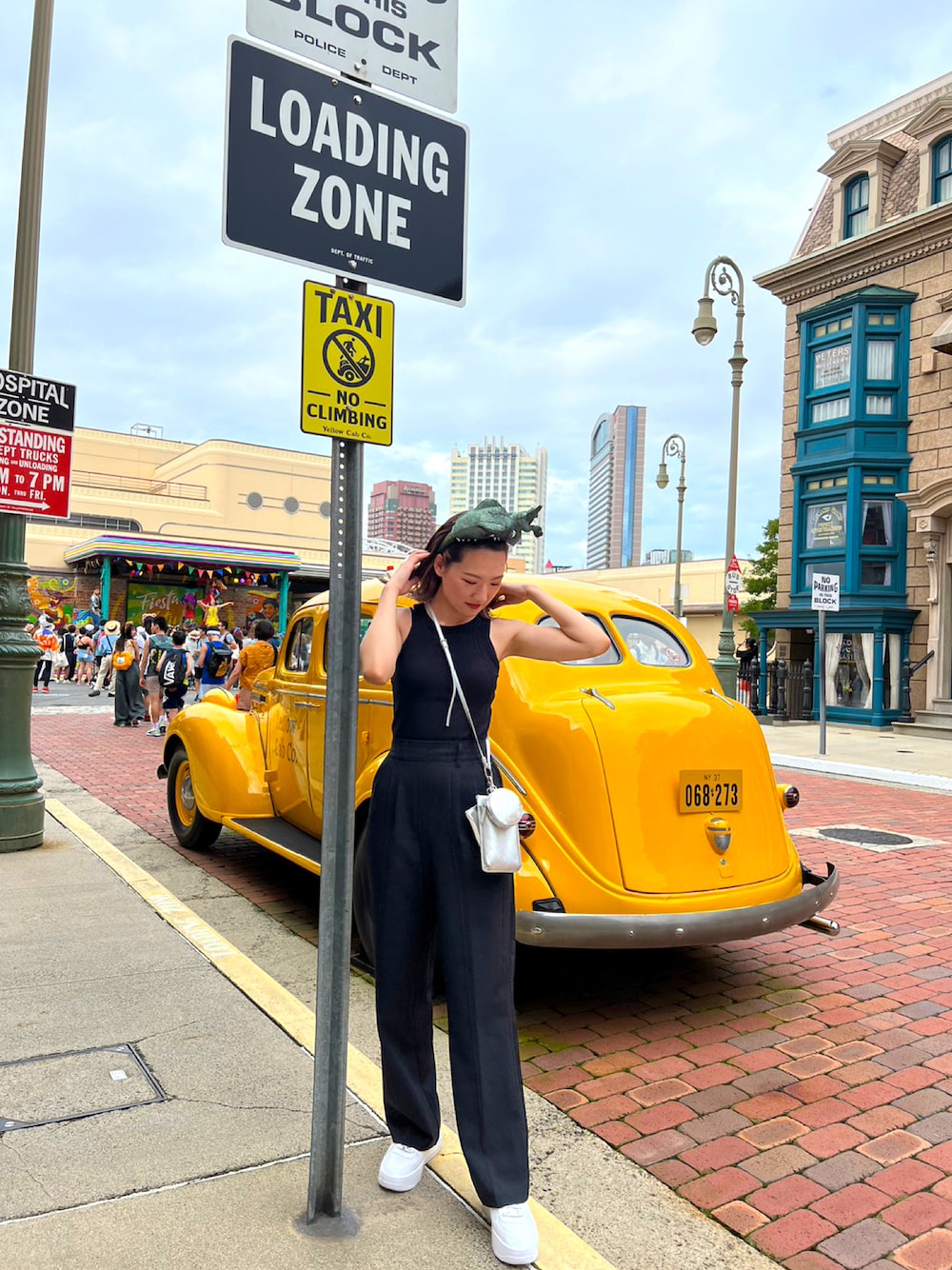 ブラック系のタンクトップ、ブラック系のスラックス、ホワイト系のスニーカーを着用したレディースの夏コーディネートの1枚目の写真