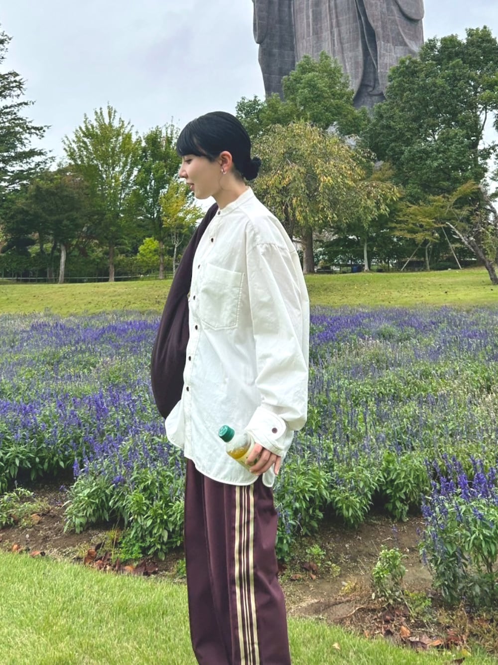 ブラウン系のパンツ、ブラウン系のビジネスバッグ、ホワイト系のシャツ/ブラウスを着用したレディースの秋コーディネートの1枚目の写真