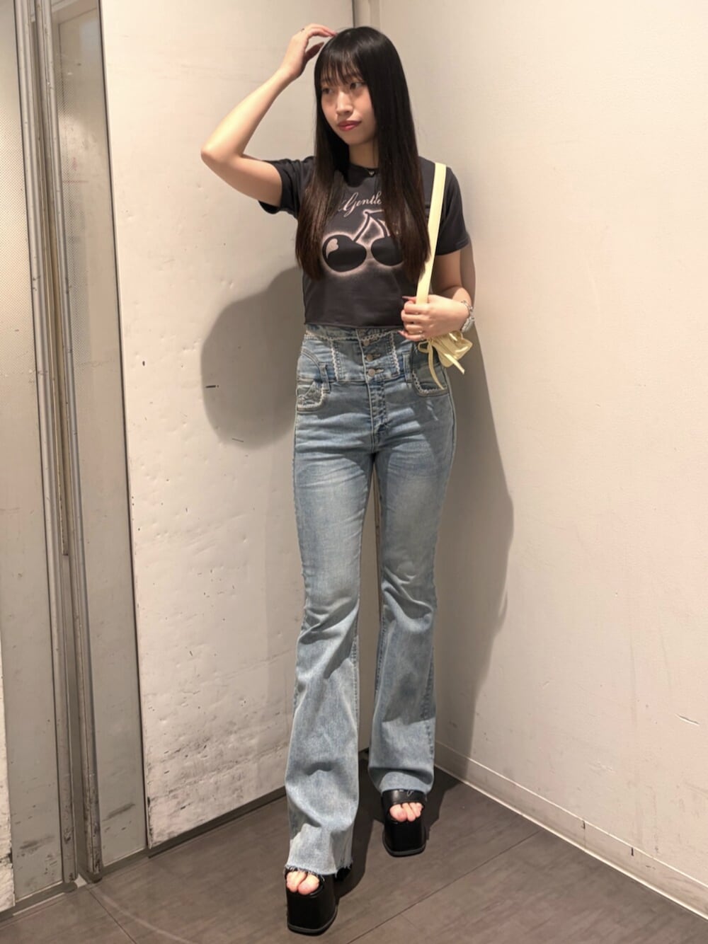 ブラック系のサンダル、グレー系のTシャツ/カットソー、イエロー系のハンドバッグを着用したレディースの春コーディネートの1枚目の写真
