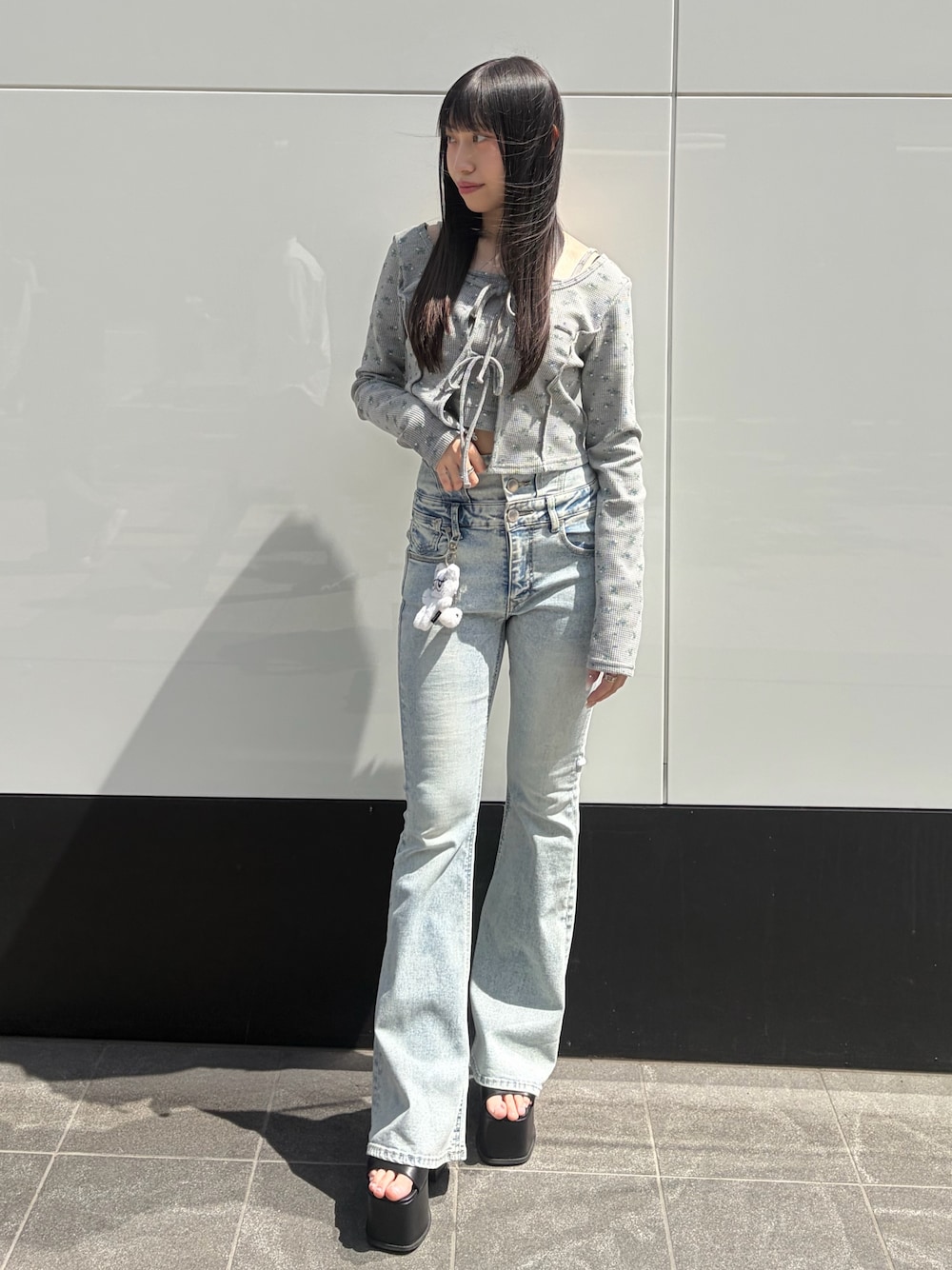 グレー系のTシャツ/カットソー、ブルー系のデニムパンツ、ブラック系のサンダルを着用したレディースの春コーディネートの1枚目の写真