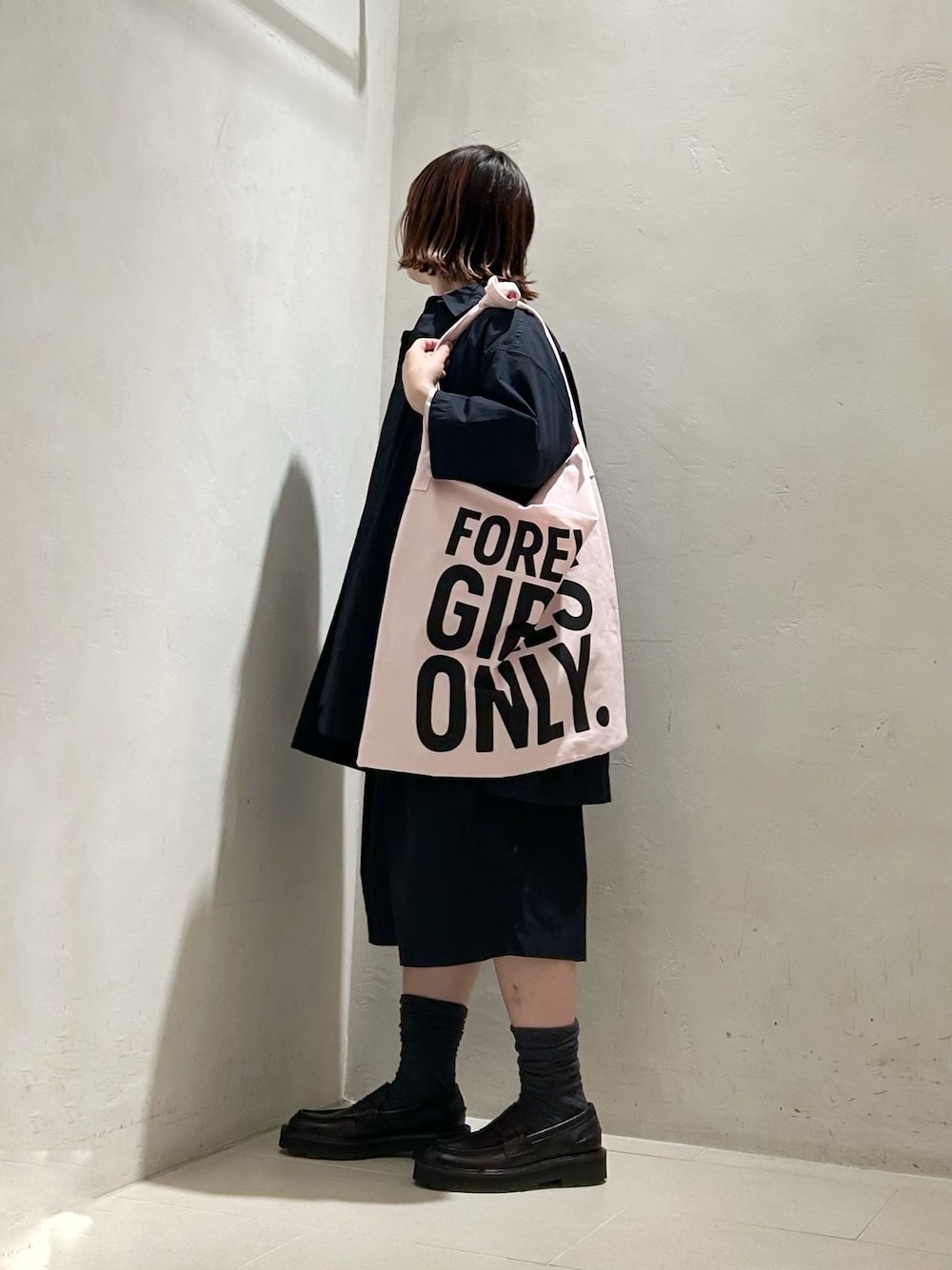 ピンク系のシャツ/ブラウス、ホワイト系のニット/セーター、グレー系のソックス/靴下を着用したレディースの春コーディネートの1枚目の写真