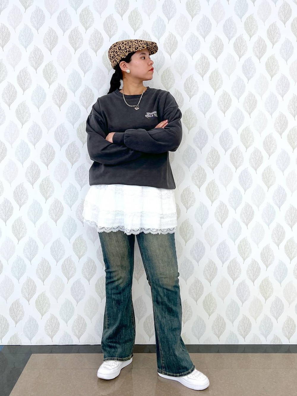 ブルー系のデニムパンツ、グレー系のスウェット、ホワイト系のスカートを着用したレディースの春コーディネートの1枚目の写真