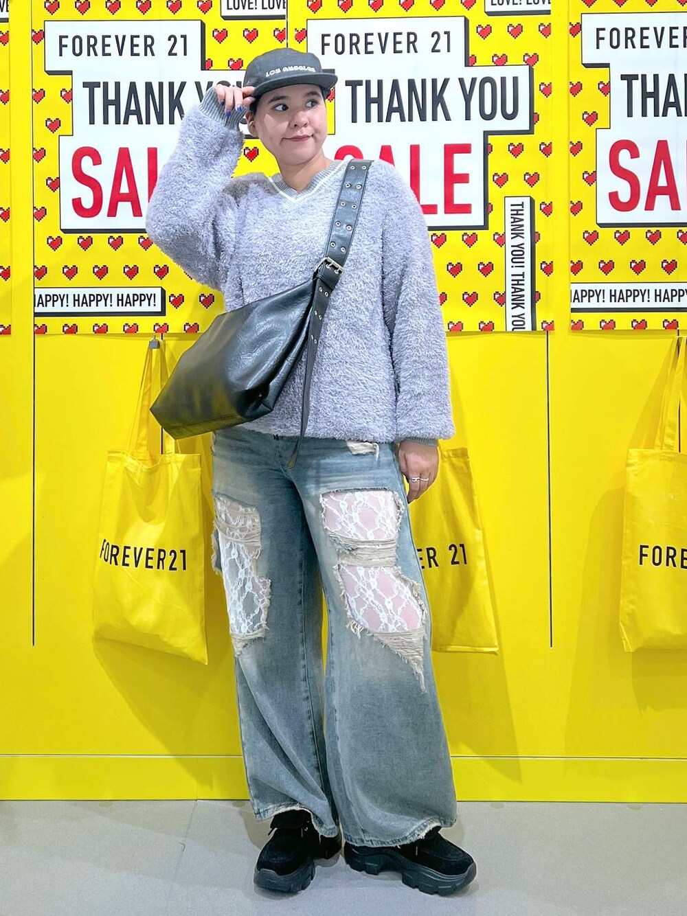 グレー系のニット/セーター、ブルー系のデニムパンツ、ブラック系のモカシン/デッキシューズを着用したレディースの秋コーディネートの1枚目の写真