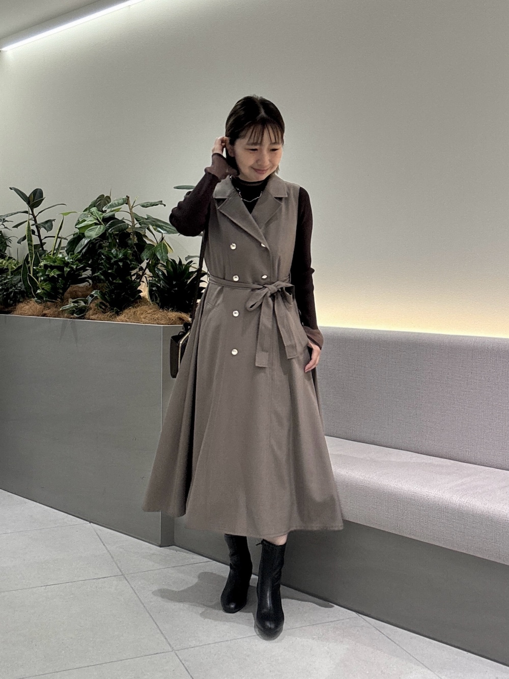 ブラウン系のニット/セーター、ブラウン系のワンピース、ブラック系のショルダーバッグを着用したレディースの秋コーディネートの1枚目の写真