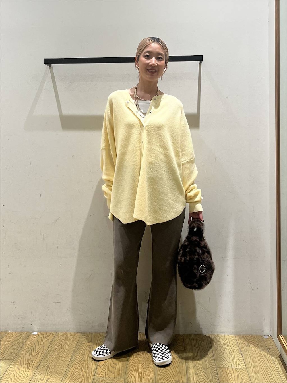 ブラウン系のその他パンツ、その他のハンドバッグ、ホワイト系のキャミソールを着用したレディースの秋コーディネートの1枚目の写真