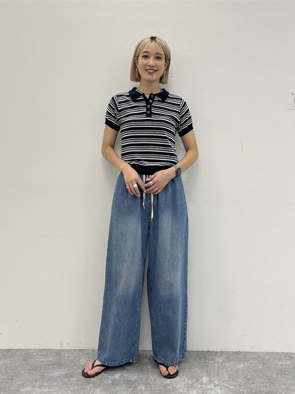 ブルー系のデニムパンツ、ブルー系のポロシャツを着用したレディースの夏コーディネートの1枚目の写真