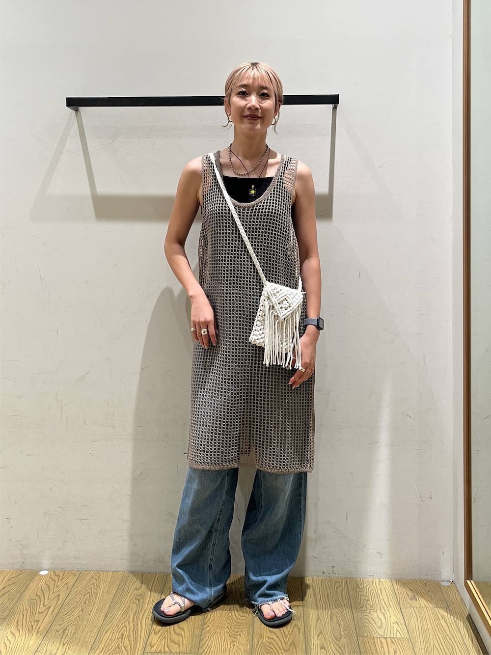 ブルー系のデニムパンツ、ベージュ系のワンピース、ベージュ系のショルダーバッグを着用したレディースの夏コーディネートの1枚目の写真