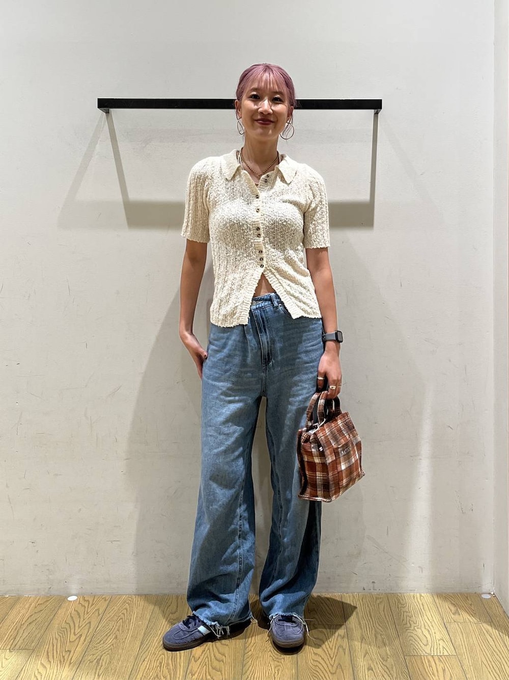 ブルー系のデニムパンツ、オレンジ系のトートバッグ、ホワイト系のニット/セーターを着用したレディースの夏コーディネートの1枚目の写真