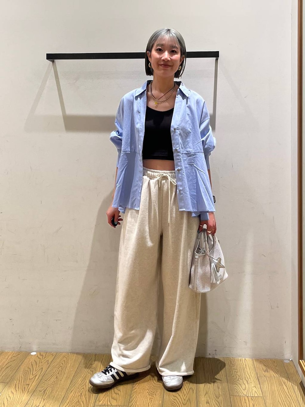 グレー系のショルダーバッグ、ブルー系のシャツ/ブラウス、ブラック系のブラジャーを着用したレディースの春コーディネートの1枚目の写真