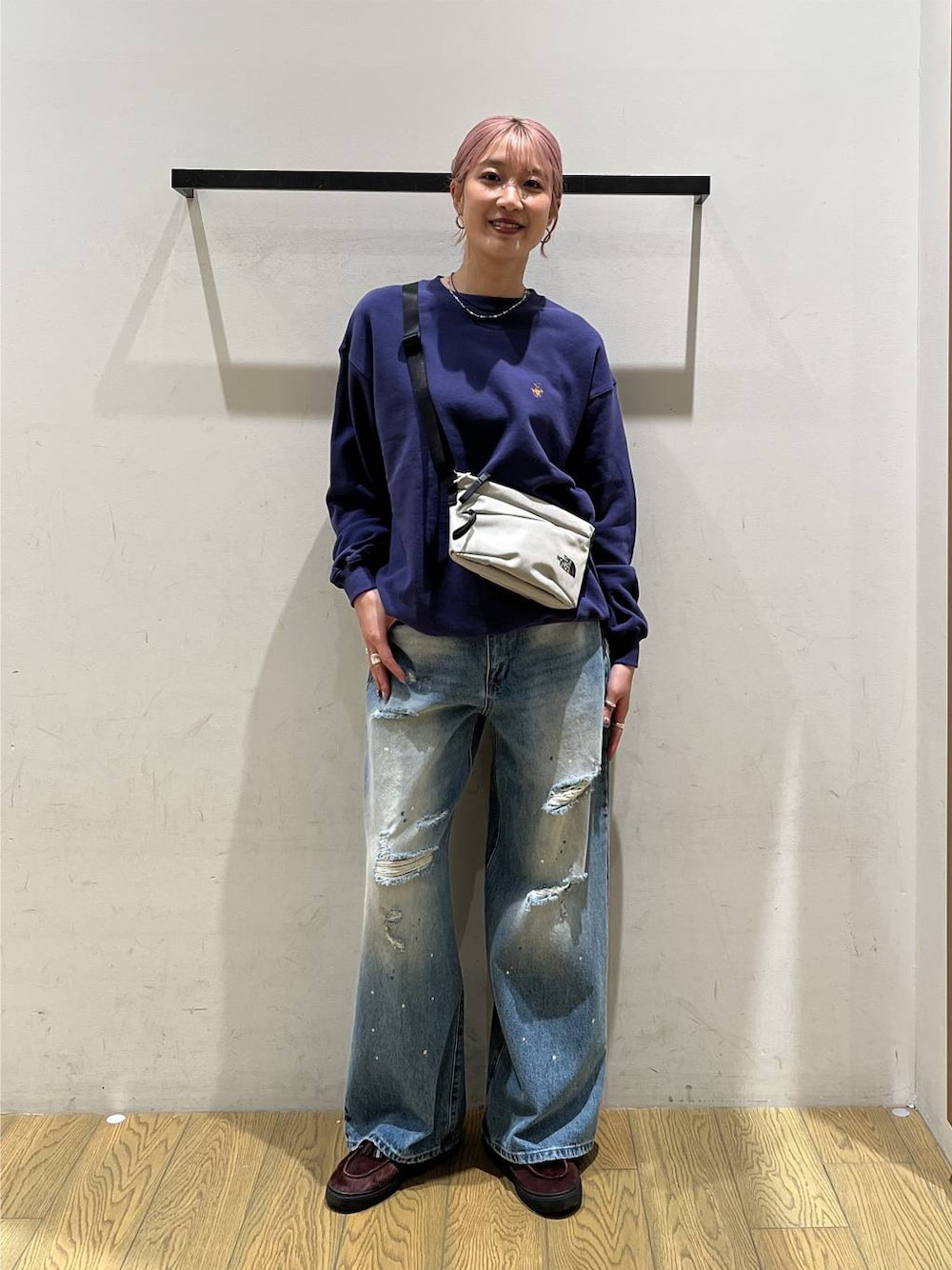 ブルー系のデニムパンツ、グレー系のショルダーバッグ、ブルー系のスウェットを着用したレディースの秋コーディネートの1枚目の写真