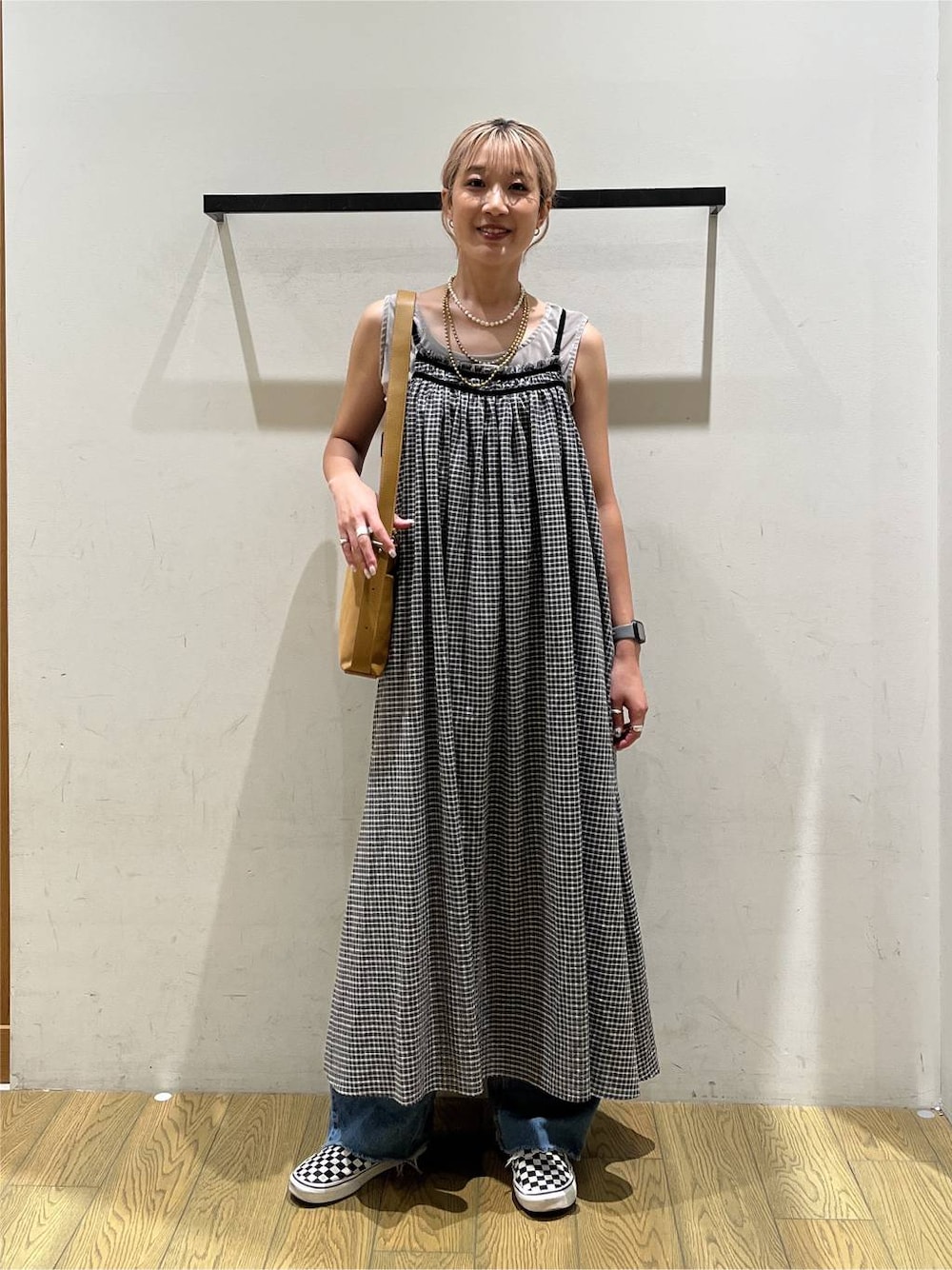 グレー系のワンピース、ブルー系のデニムパンツ、ベージュ系のタンクトップを着用したレディースの夏コーディネートの1枚目の写真