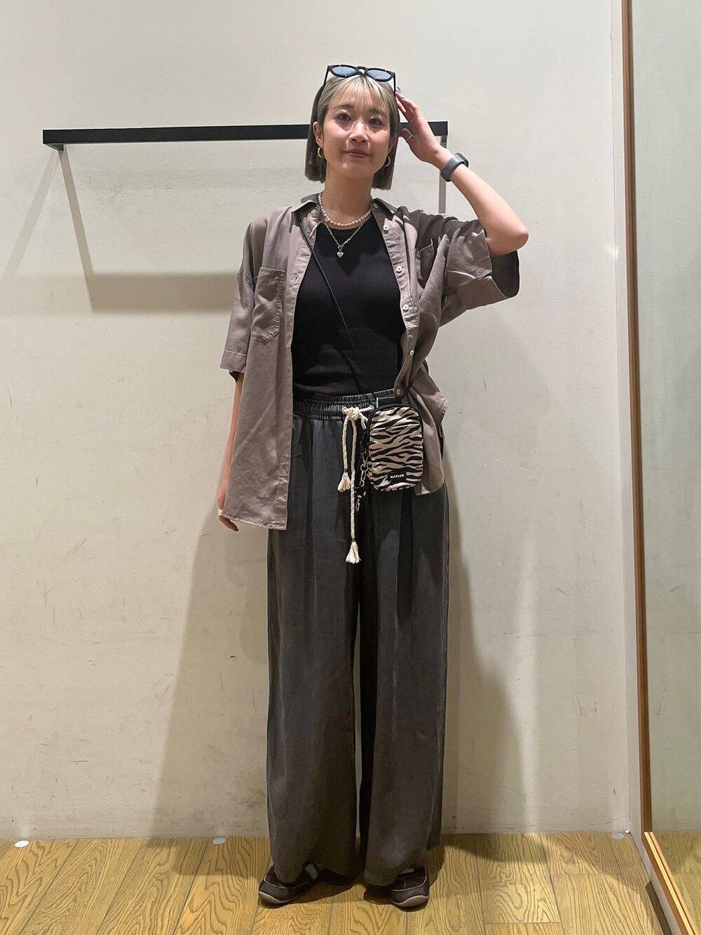 ベージュ系のショルダーバッグ、ブラウン系のシャツ/ブラウス、グレー系のその他パンツを着用したレディースの春コーディネートの1枚目の写真