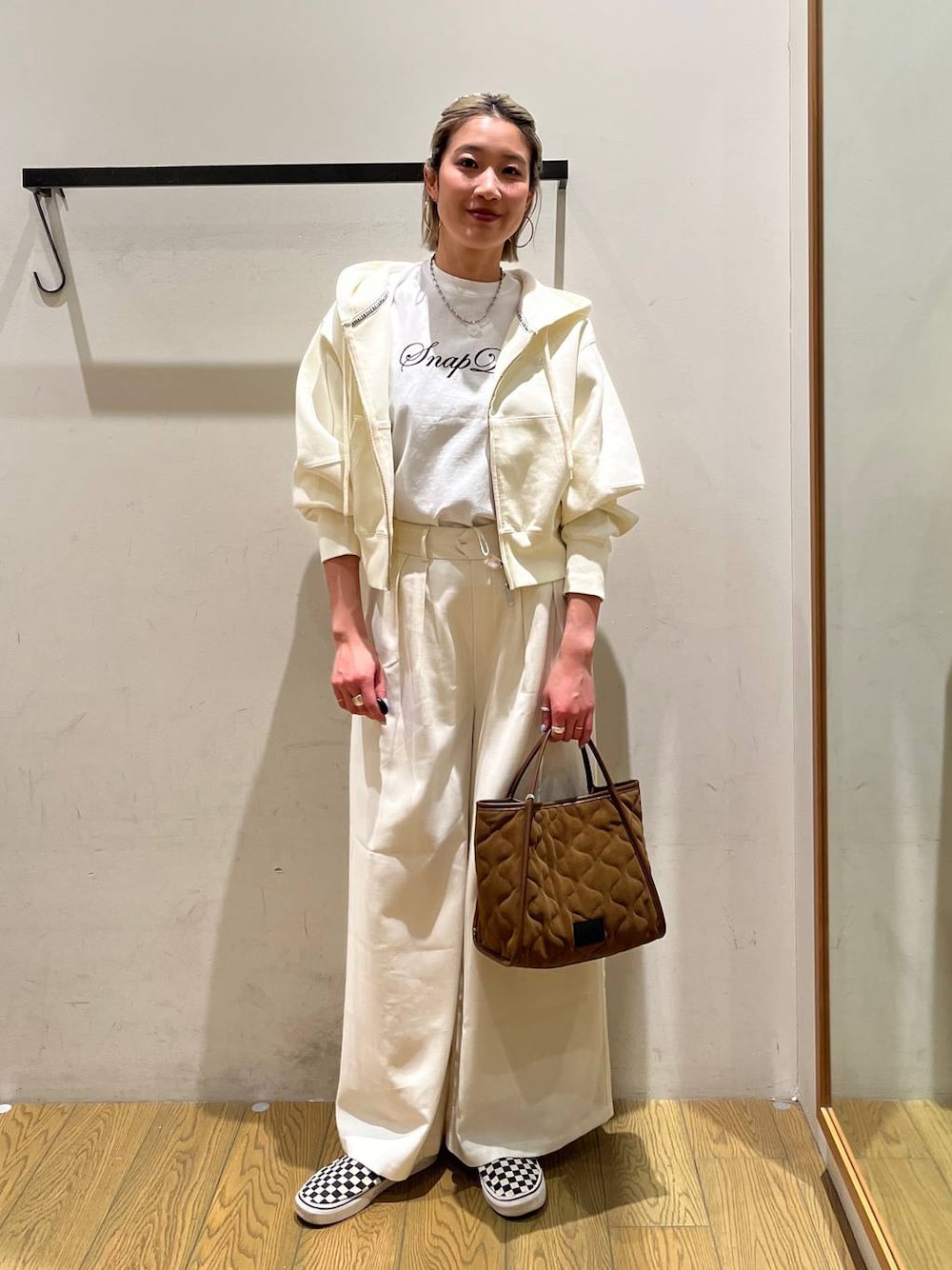 イエロー系のハンドバッグ、ベージュ系のその他パンツ、ホワイト系のTシャツ/カットソーを着用したレディースの春コーディネートの1枚目の写真