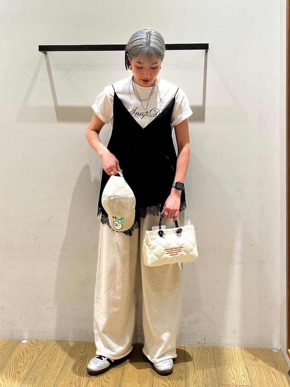 ブラック系のキャミソール、ホワイト系のTシャツ/カットソー、ホワイト系のショルダーバッグを着用したレディースの春コーディネートの1枚目の写真