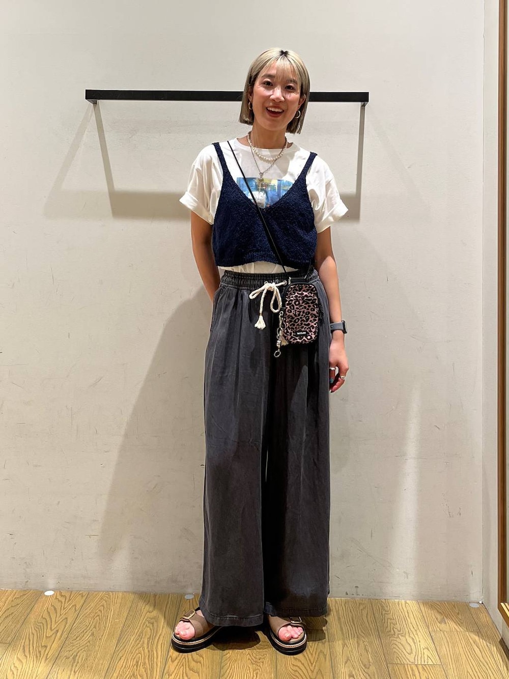 ブラウン系のショルダーバッグ、ブラック系のデニムパンツ、ベージュ系のサンダルを着用したレディースの春コーディネートの1枚目の写真
