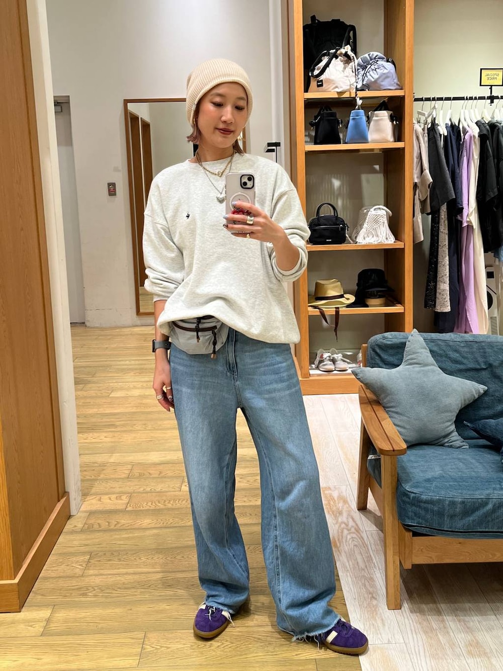 ブルー系のデニムパンツ、ブルー系のショルダーバッグ、グレー系のスウェットを着用したレディースの秋コーディネートの1枚目の写真