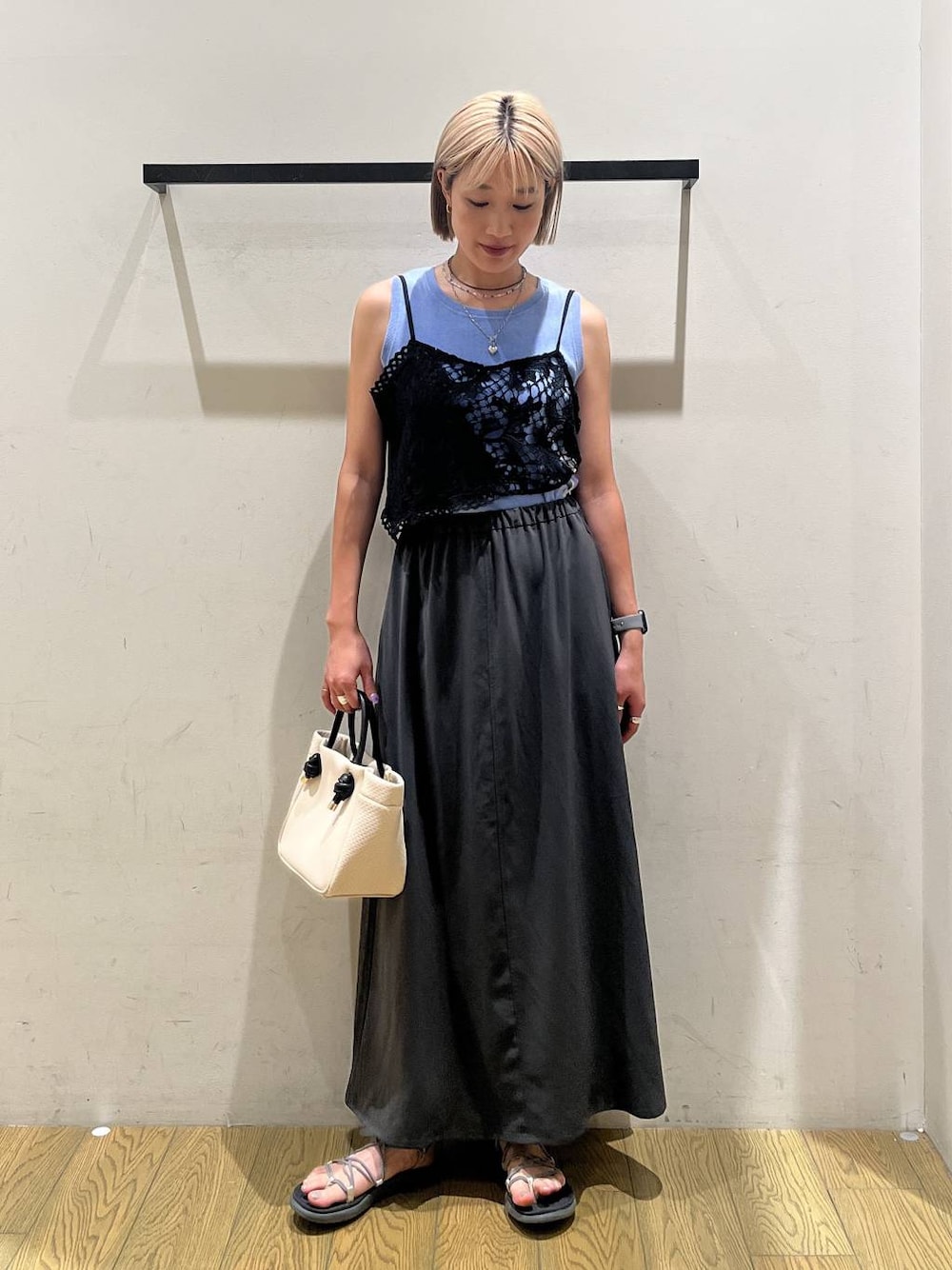 ベージュ系のショルダーバッグ、グレー系のスカート、ブルー系のTシャツ/カットソーを着用したレディースの春コーディネートの1枚目の写真