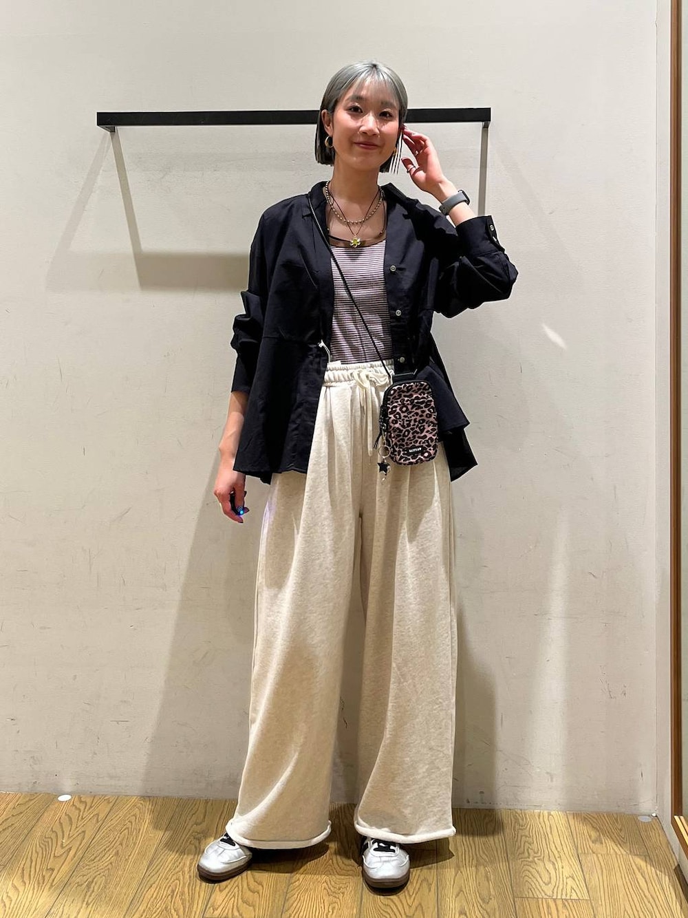 ブラウン系のショルダーバッグ、ブラウン系のタンクトップ、ブラック系のシャツ/ブラウスを着用したレディースの春コーディネートの1枚目の写真