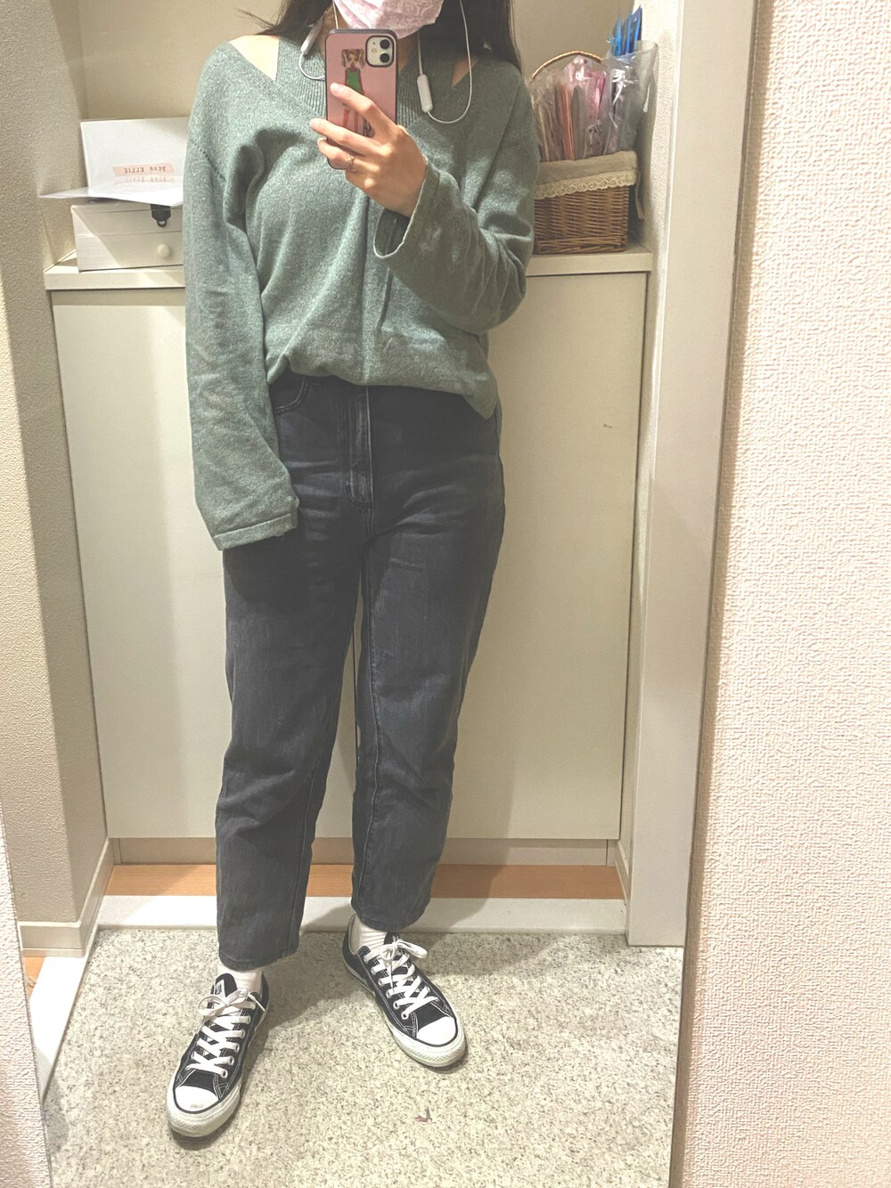 グリーン系のニット/セーター、ブラック系のスニーカーを着用したレディースの春コーディネートの1枚目の写真