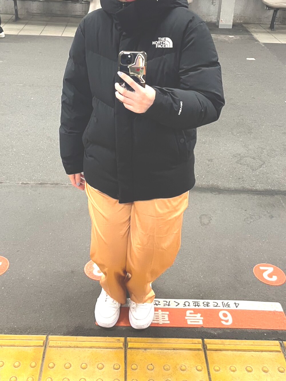 「ダウンジャケット、サテンパンツ、白スニーカー、オレンジ、カラーパンツ、reebok、スニーカー、3色コーデ」｜「THE NORTH FACEのアイテム（ダウンジャケット/コート、ブラック系）」を使った、m.さん（レディース・161cm）の夏コーディネートの1枚目の写真