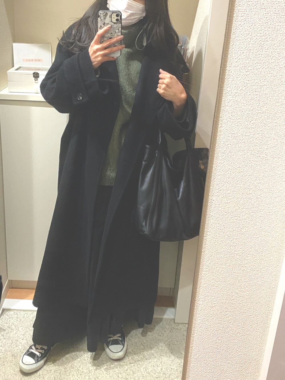 グリーン系のニット/セーター、ブラック系のショルダーバッグ、ブラック系のスニーカーを着用したレディースの春コーディネートの1枚目の写真