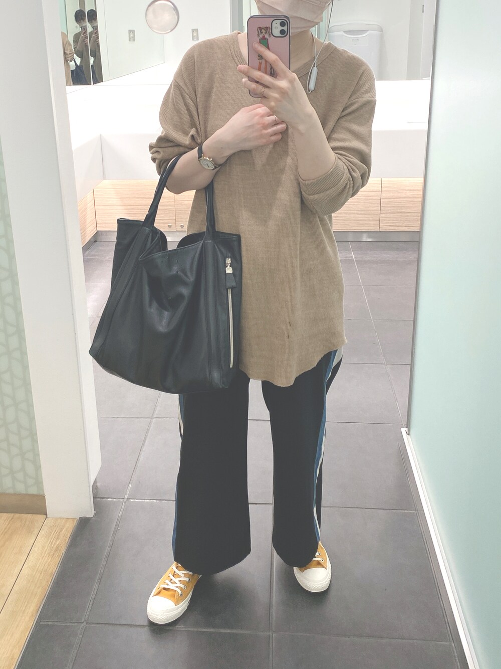 ブラック系のショルダーバッグ、ベージュ系のTシャツ/カットソー、ブラック系のその他パンツを着用したレディースの春コーディネートの1枚目の写真