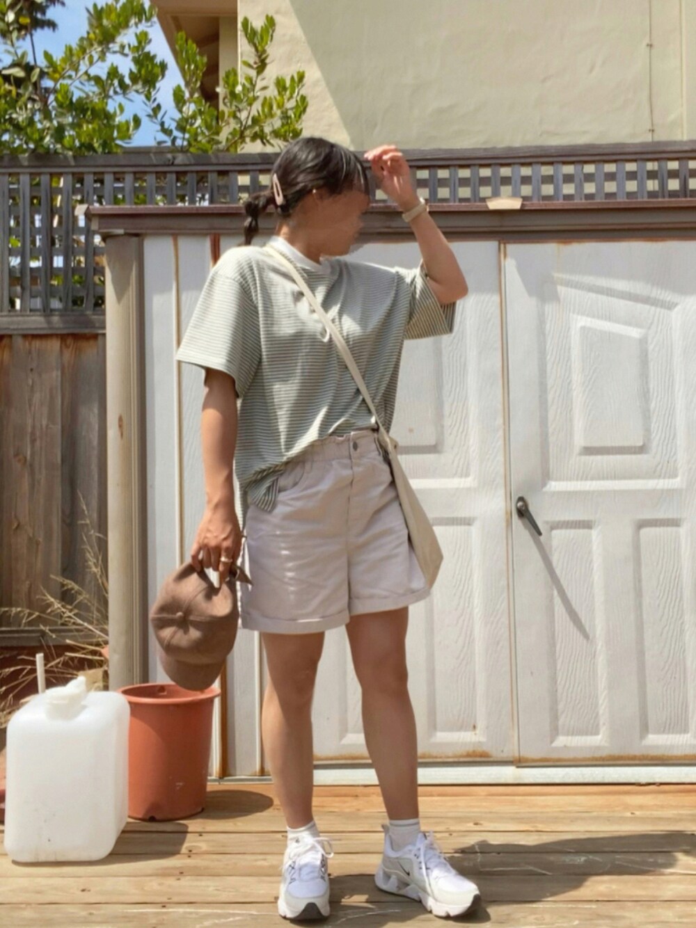 グリーン系のTシャツ/カットソー、ホワイト系のトートバッグ、ベージュ系のパンツを着用したレディースの夏コーディネートの1枚目の写真