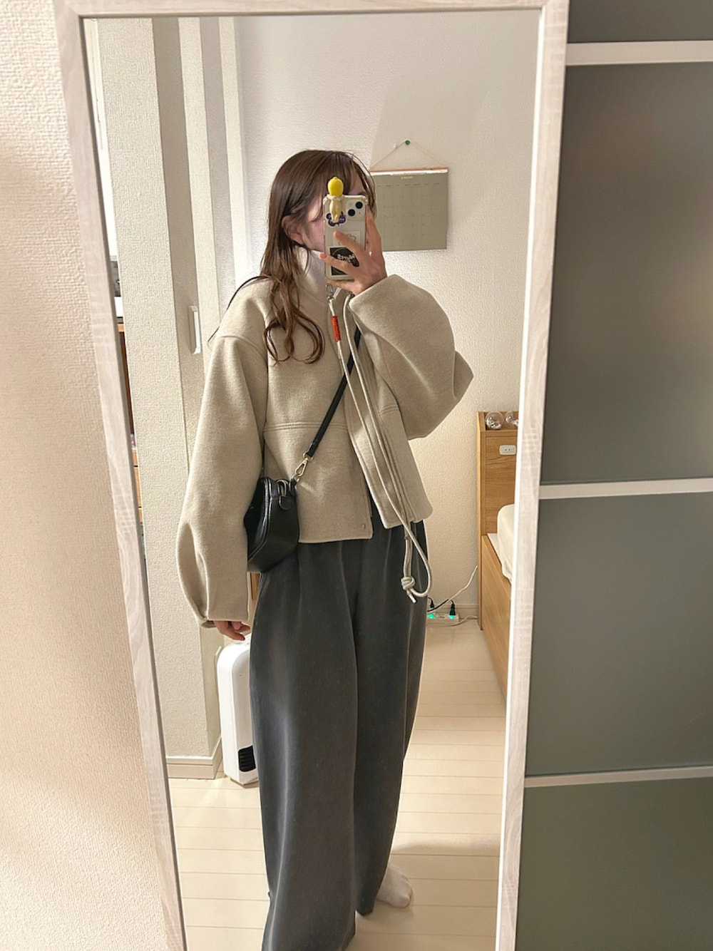 ホワイト系のその他アウター、ホワイト系のトップス、グレー系のその他パンツを着用したレディースの冬コーディネートの1枚目の写真