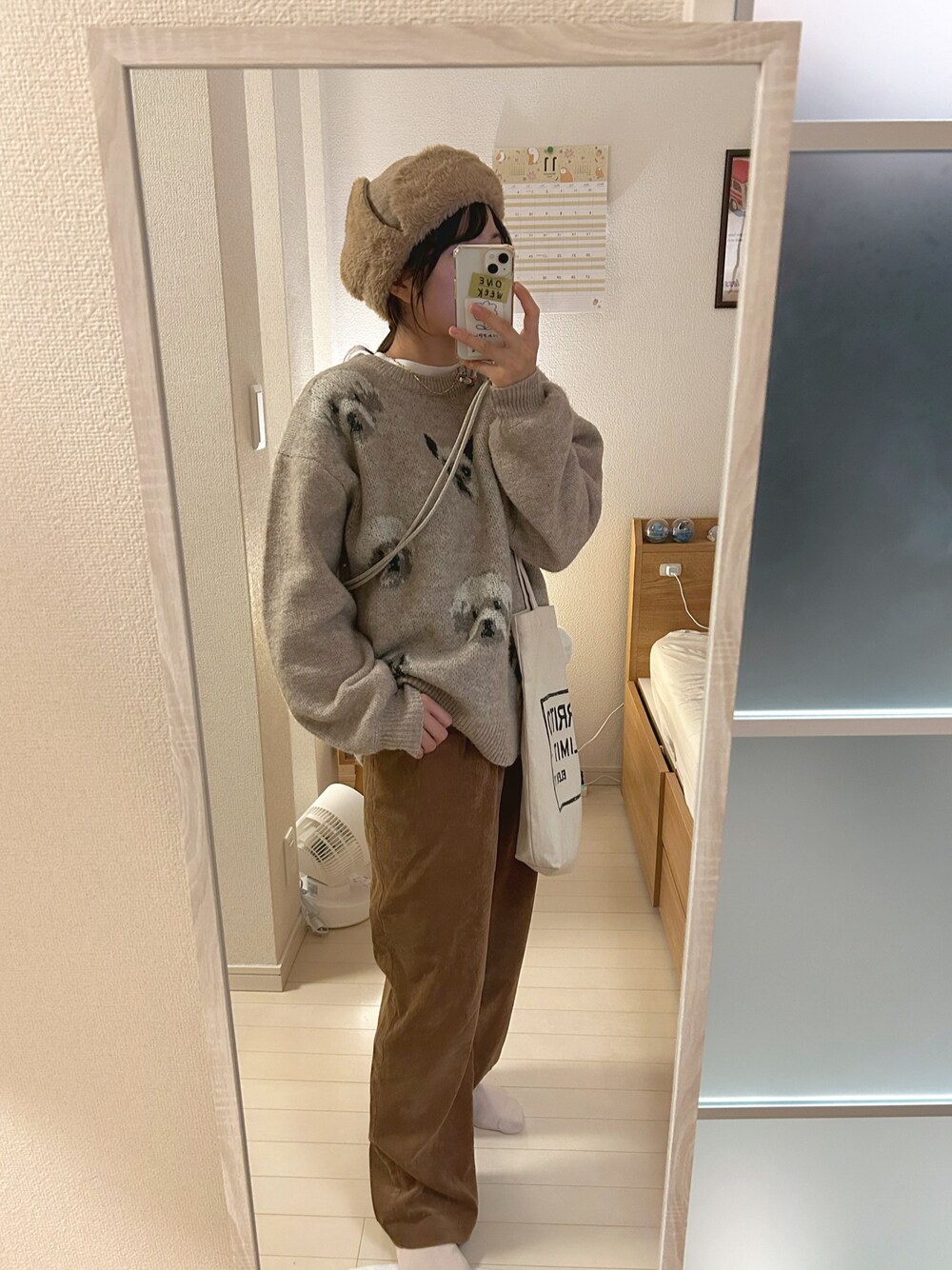 ベージュ系のニット/セーター、ブラウン系のその他パンツ、ホワイト系のTシャツ/カットソーを着用したレディースの秋コーディネートの1枚目の写真