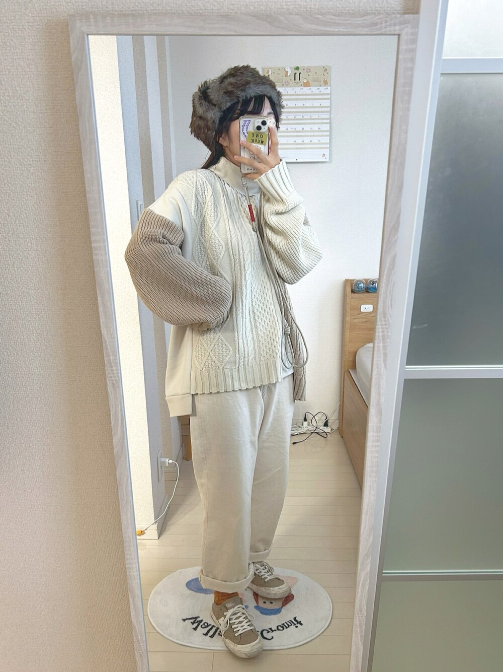 ホワイト系のニット/セーター、ホワイト系のデニムパンツ、ベージュ系のスニーカーを着用したレディースの冬コーディネートの1枚目の写真