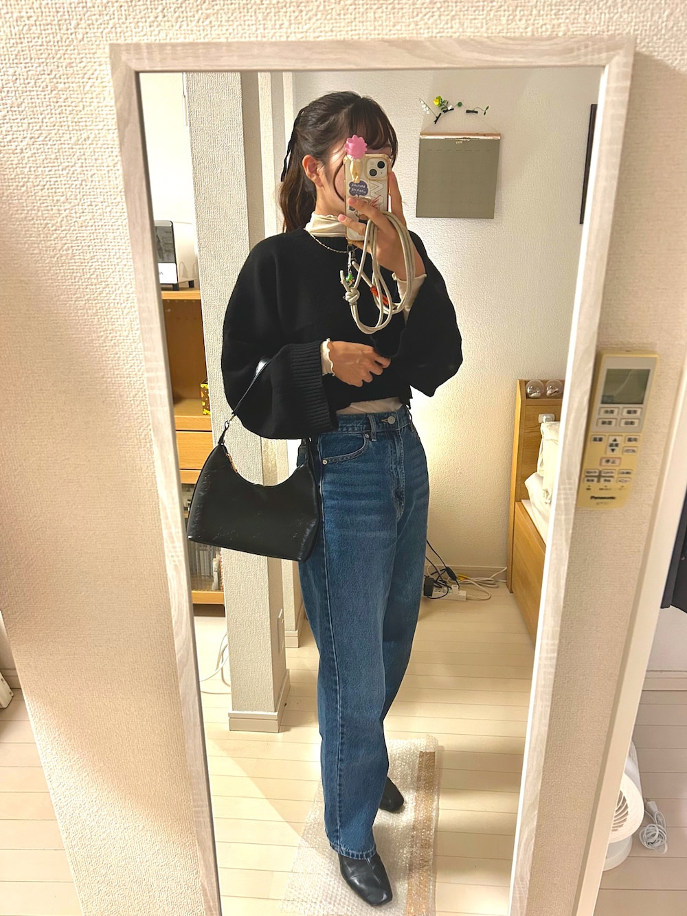 ホワイト系のTシャツ/カットソー、ブラック系のニット/セーター、ブルー系のデニムパンツを着用したレディースの秋コーディネートの1枚目の写真