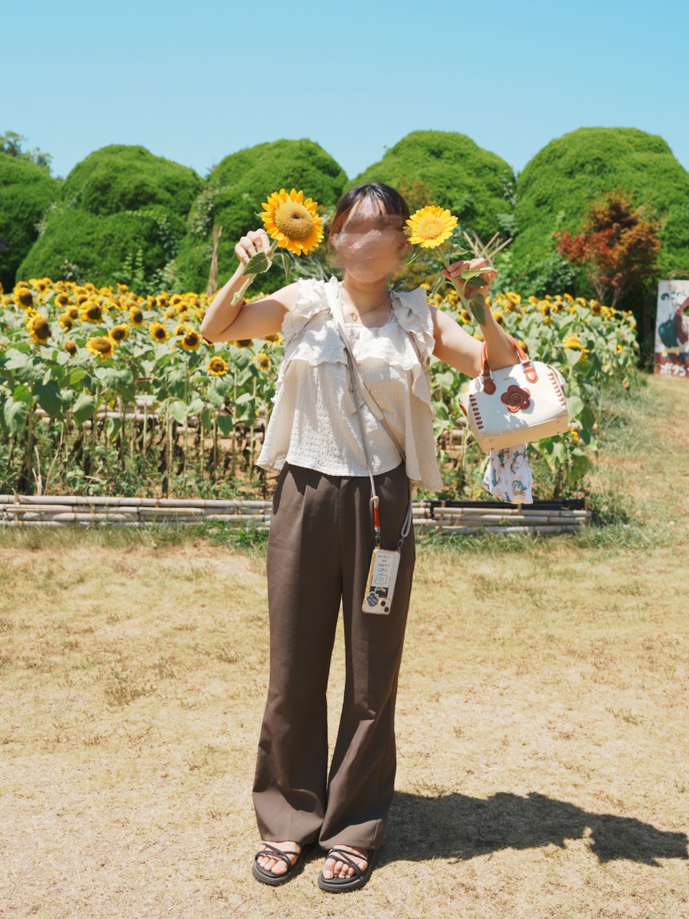 グリーン系のシャツ/ブラウス、ベージュ系のトートバッグ、グレー系のスラックスを着用したレディースの夏コーディネートの1枚目の写真