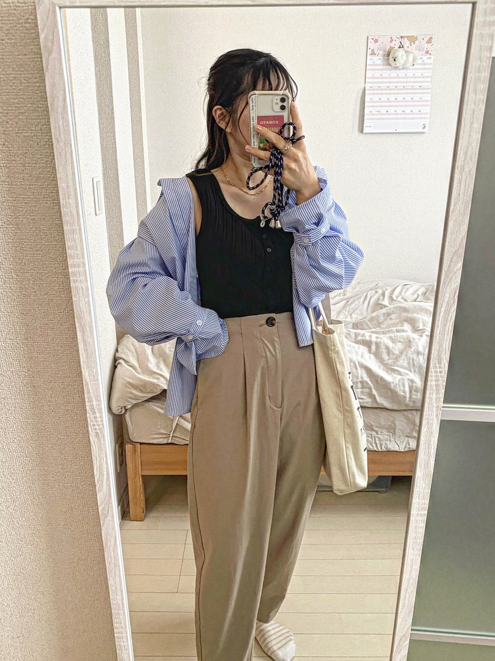 ブラック系のタンクトップ、ブルー系のシャツ/ブラウス、ベージュ系のパンツを着用したレディースの春コーディネートの1枚目の写真