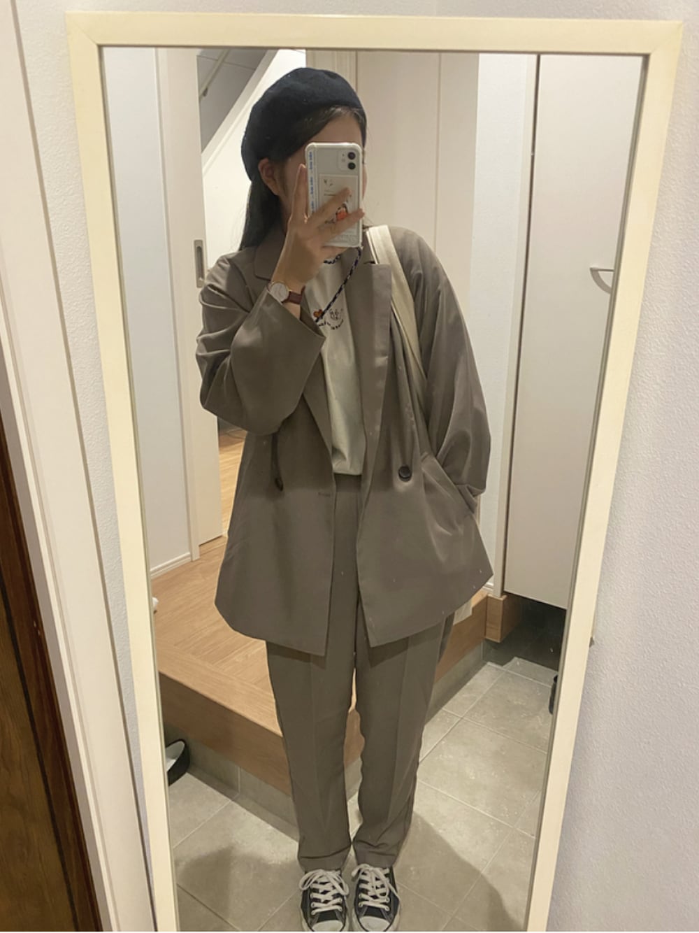 ベージュ系のTシャツ/カットソー、ベージュ系のセットアップ、ブラック系のスニーカーを着用したレディースの冬コーディネートの1枚目の写真