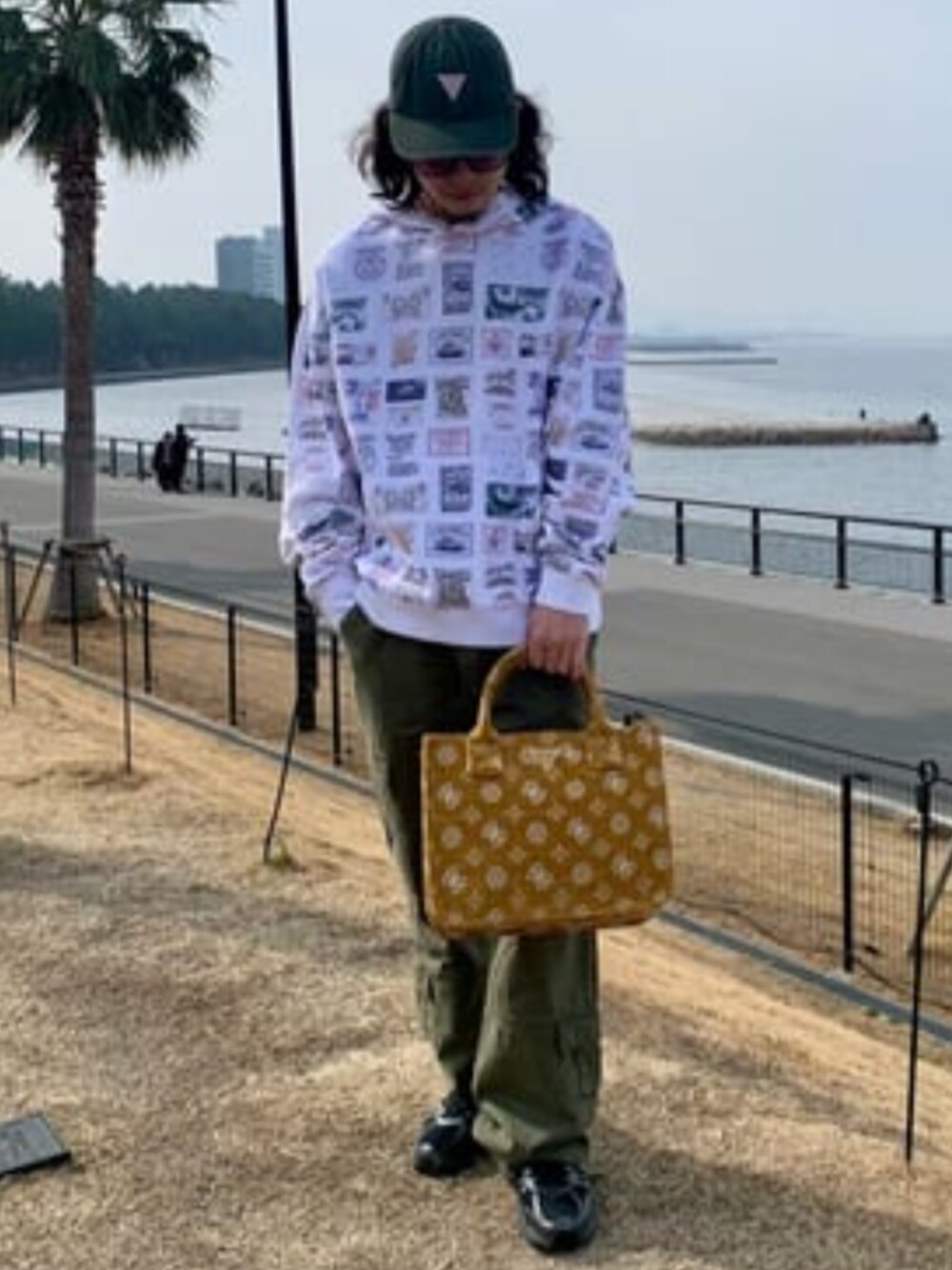 「GUESS、guess、総柄、総柄トップス、カーゴパンツ、春コーデ、春」｜「GuessのSEVYE 2 Compartment Tote（トートバッグ、イエロー系）」を使った、GUESS JAPANさん（メンズ・173cm）の冬コーディネートの1枚目の写真
