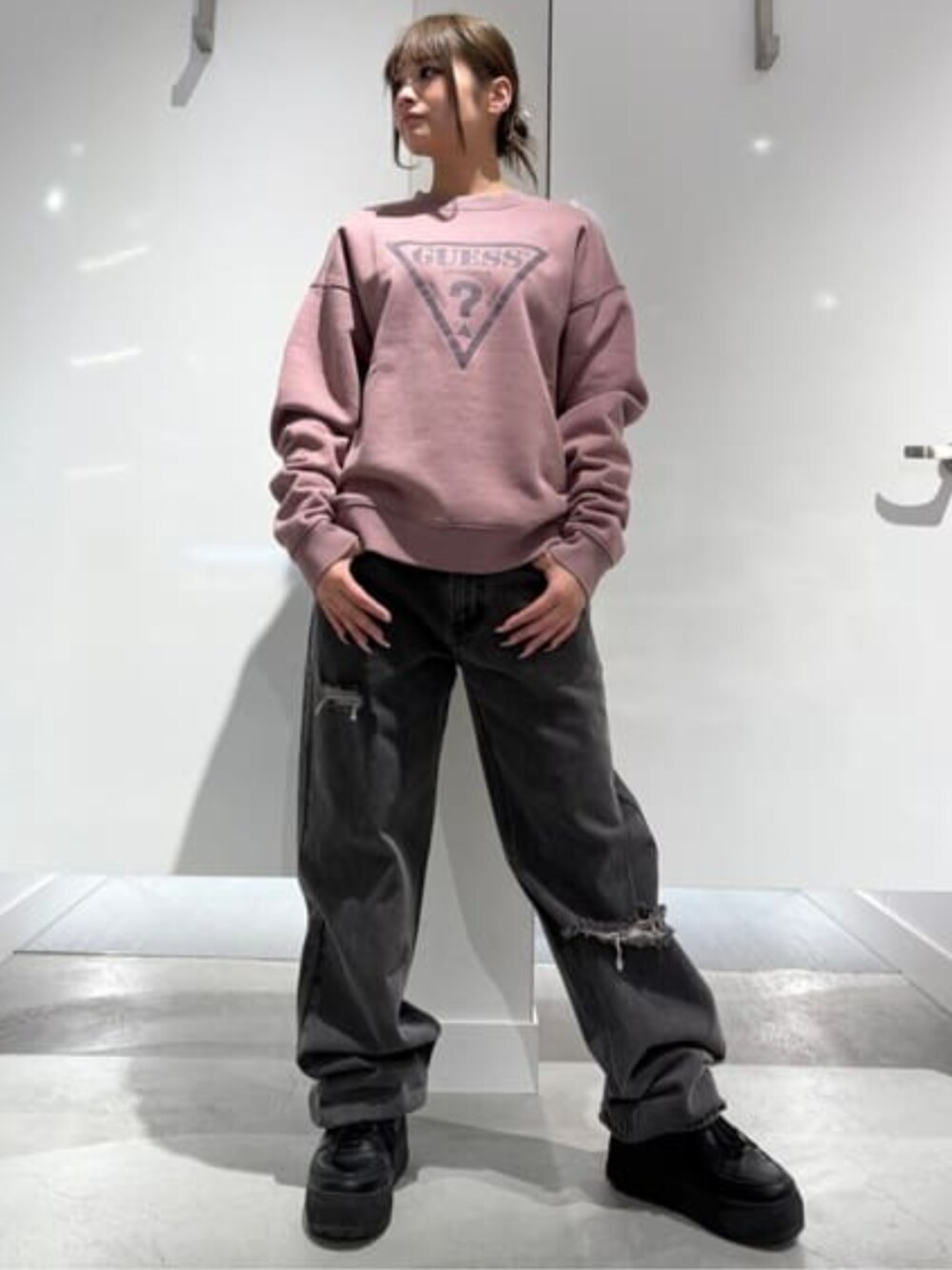 グレー系のデニムパンツ、ピンク系のスウェットを着用したレディースの冬コーディネートの1枚目の写真