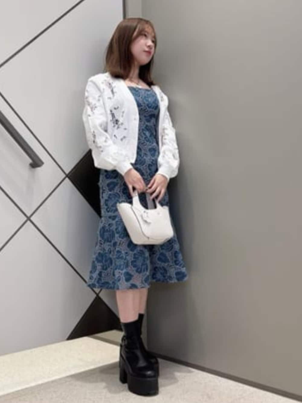 ホワイト系のショルダーバッグ、ブルー系のワンピース、ホワイト系のカーディガン/ボレロを着用したレディースの春コーディネートの1枚目の写真