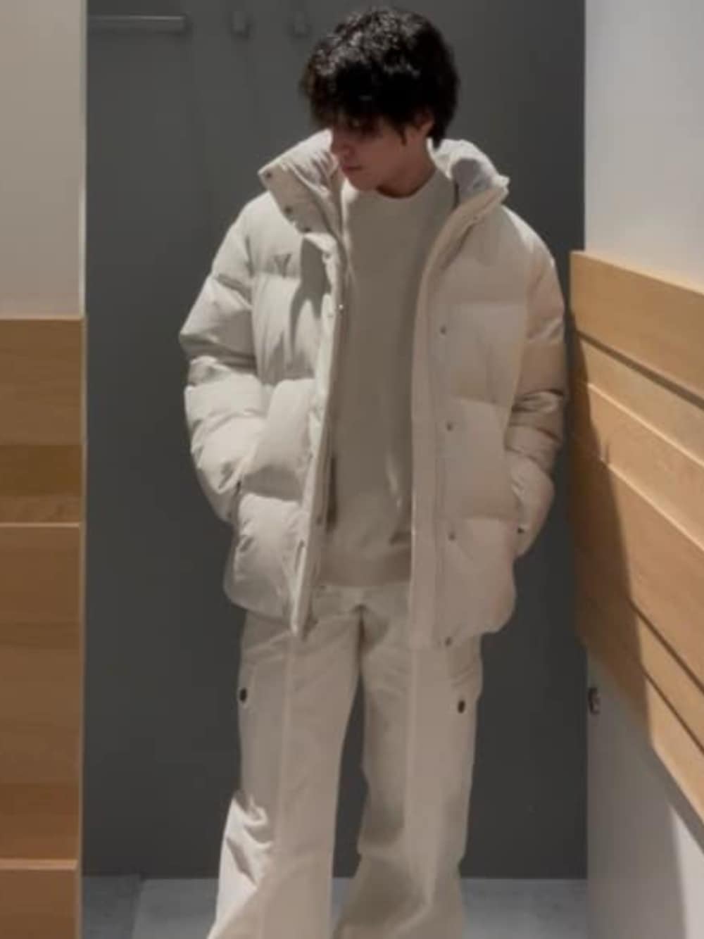 ホワイト系のカーゴパンツ、ホワイト系のニット/セーター、ホワイト系のダウンジャケット/コートを着用したメンズの冬コーディネートの1枚目の写真