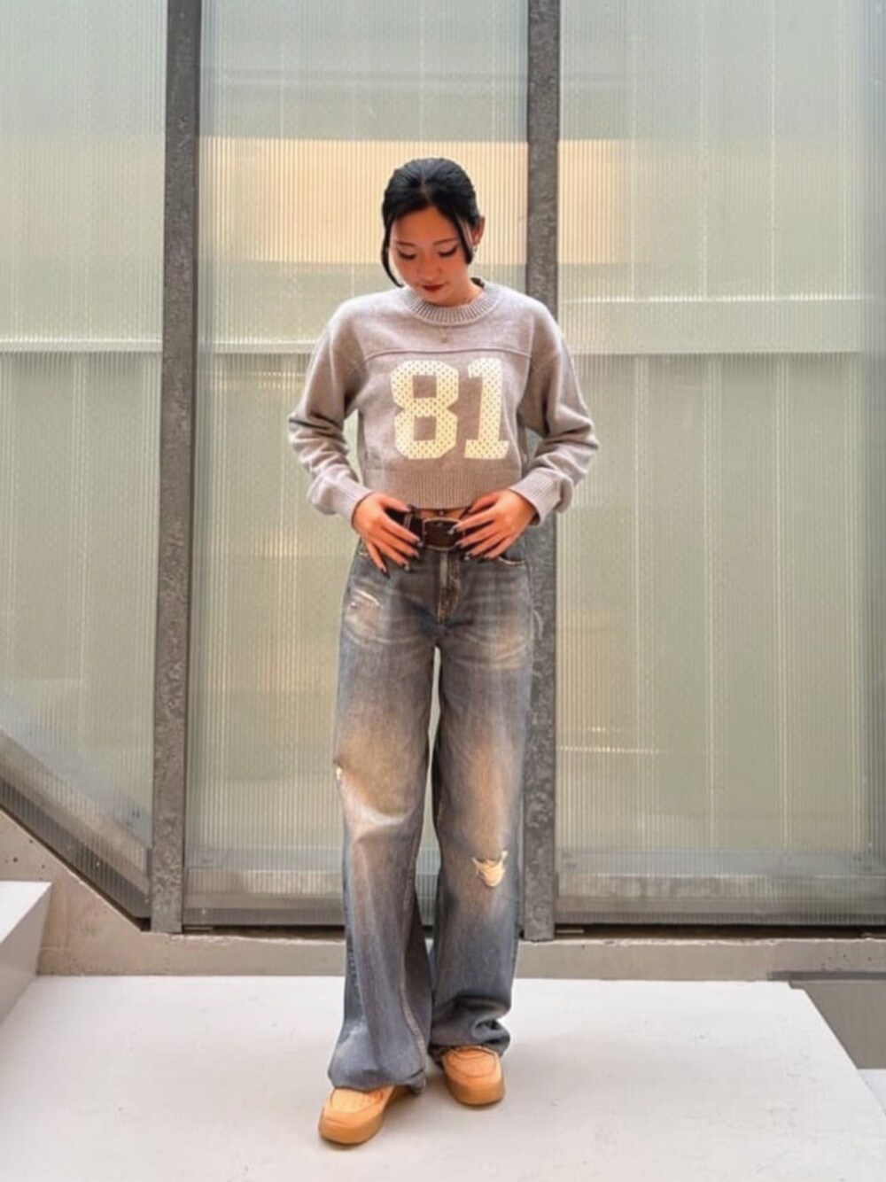 ブルー系のデニムパンツ、グレー系のニット/セーターを着用したレディースの秋コーディネートの1枚目の写真