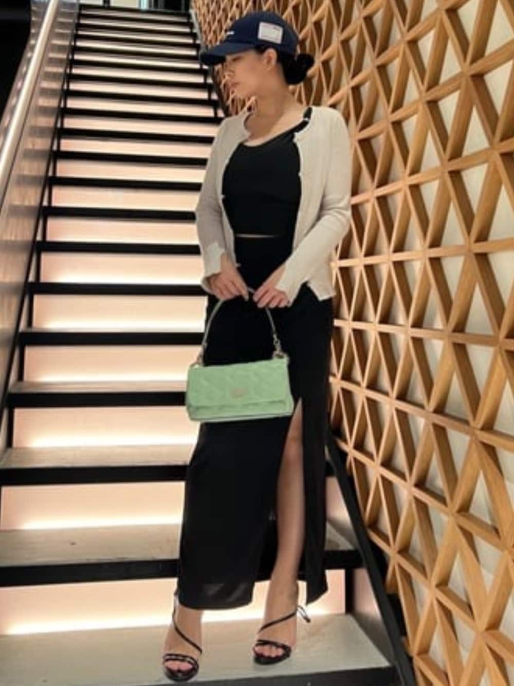 ホワイト系のニット/セーター、グリーン系のショルダーバッグ、ブラック系のタンクトップを着用したレディースの春コーディネートの1枚目の写真