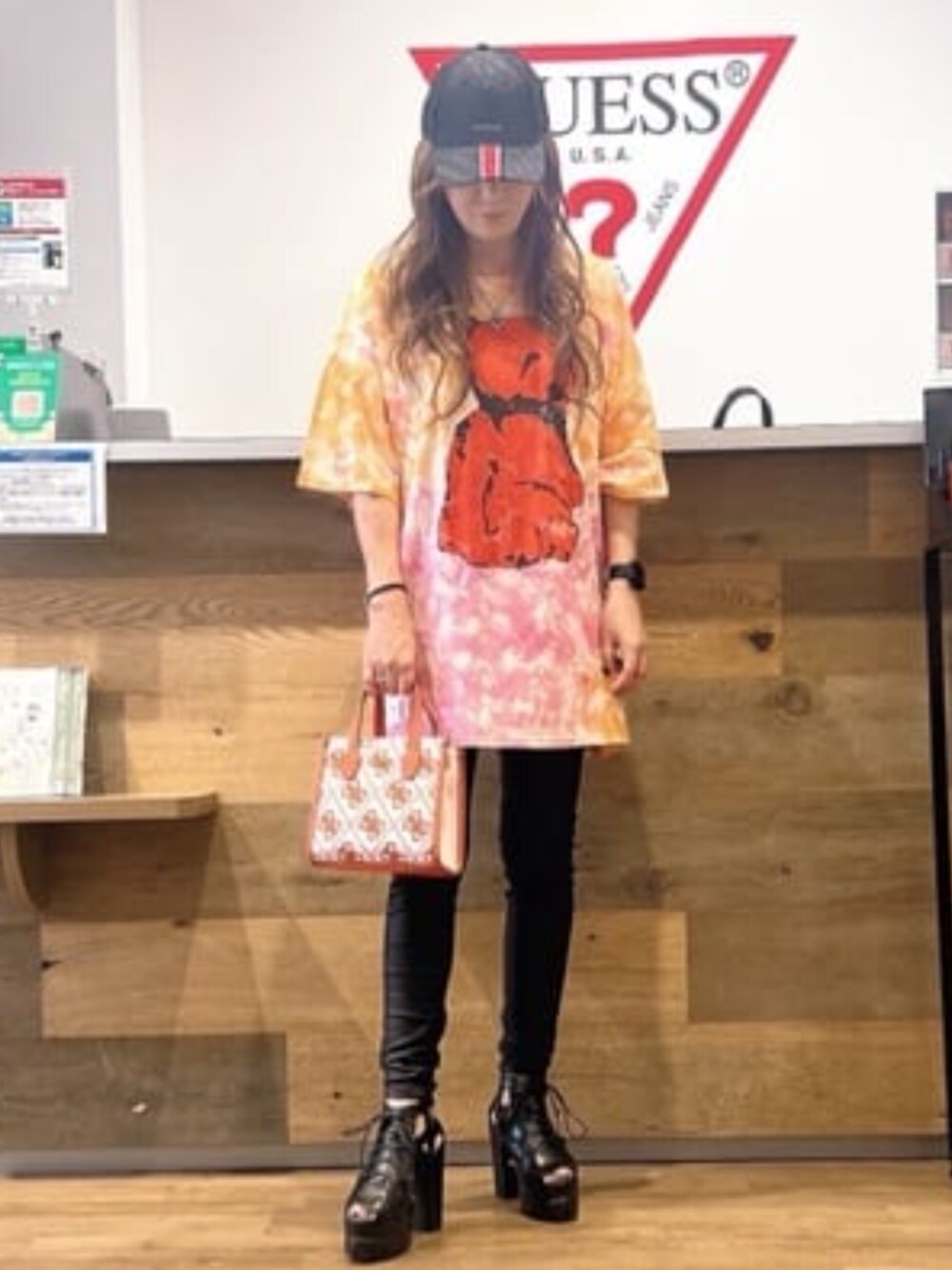 オレンジ系のTシャツ/カットソー、オレンジ系のトートバッグを着用したレディースの夏コーディネートの1枚目の写真