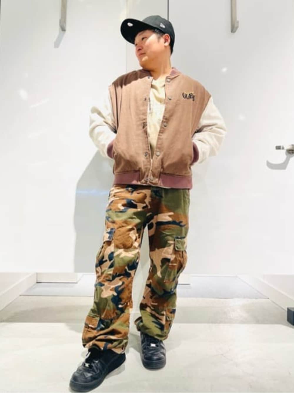 その他のカーゴパンツ、ブラウン系のスタジャン、ベージュ系のTシャツ/カットソーを着用したメンズの春コーディネートの1枚目の写真