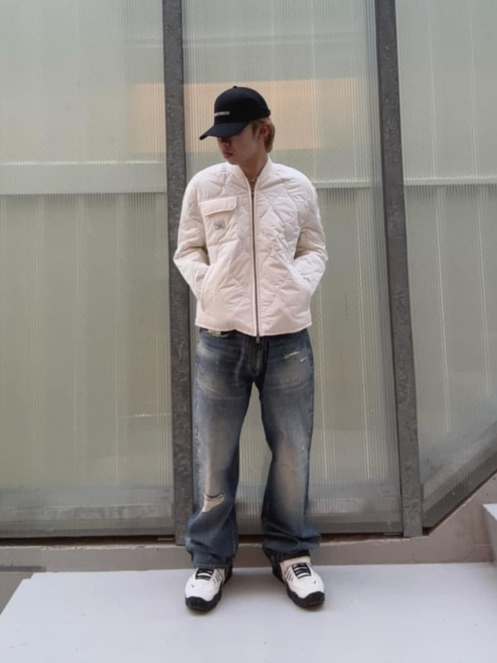 ブルー系のデニムパンツ、ホワイト系のその他アウター、ブラック系のキャップを着用したメンズの秋コーディネートの1枚目の写真