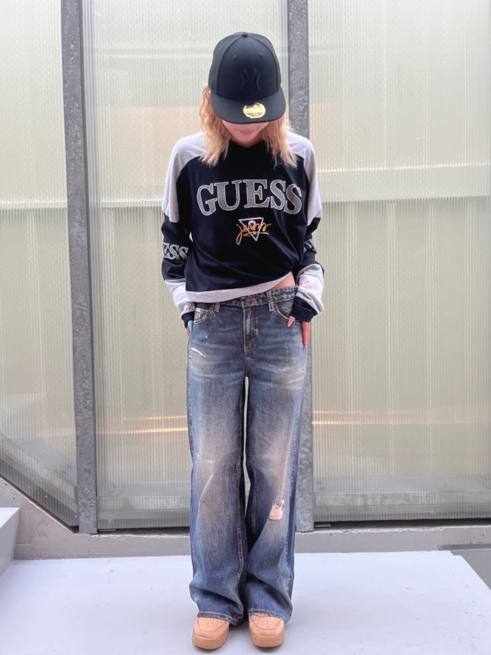 ブラック系のスウェット、ブルー系のデニムパンツを着用したレディースの夏コーディネートの1枚目の写真