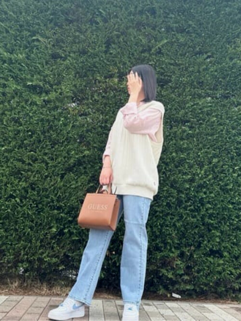 ホワイト系のベスト、ブラウン系のトートバッグ、ピンク系のシャツ/ブラウスを着用したレディースの春コーディネートの1枚目の写真