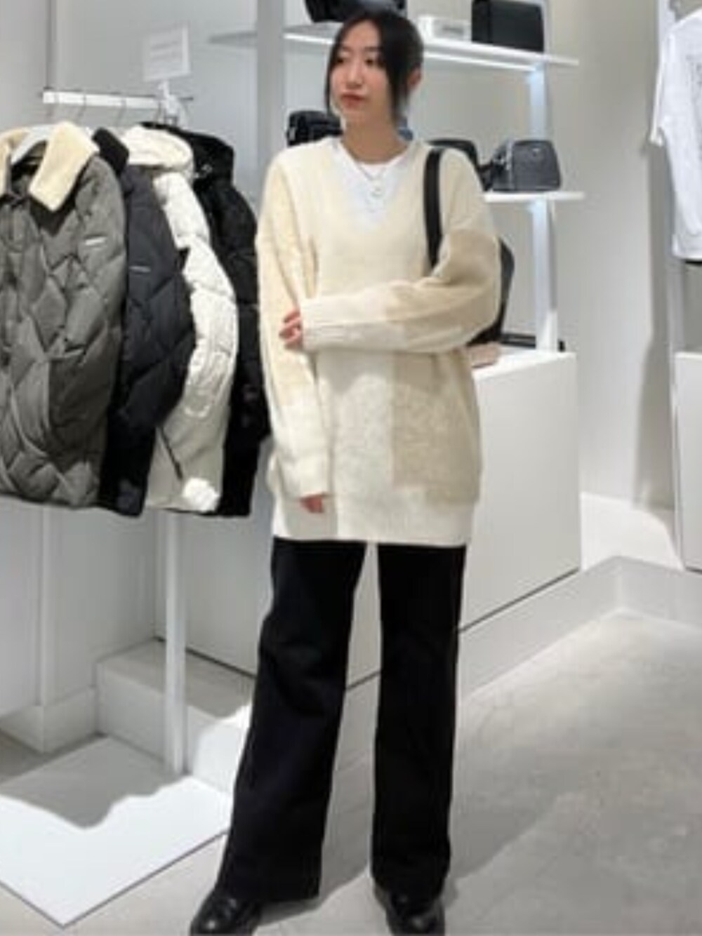 その他のニット/セーター、ブラック系のショルダーバッグ、ブラック系のデニムパンツを着用したレディースの冬コーディネートの1枚目の写真